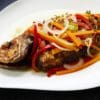 A spicy grilled fish served with vegetables