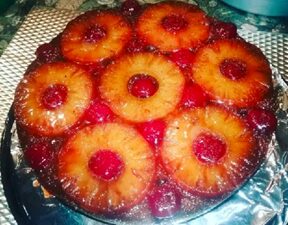 Red-colored pastry cake topped with pineapple