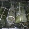Traditional wrapped food parcels tied with string, likely made from banana leaves.