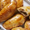 Golden-brown baked empanadas with a savory filling.