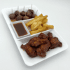 A tray with fried chicken, fries, meatballs, and dipping sauce.